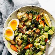 Roasted Vegetable Bowls with Green Tahini and a side of egg and a spoon in the bowl.