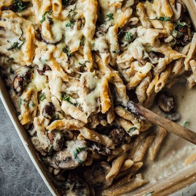 Mushroom Alfredo Pasta Bake in a pan with a spoon.