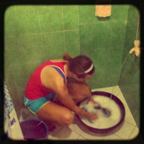 Woman washing clothes in a tub.