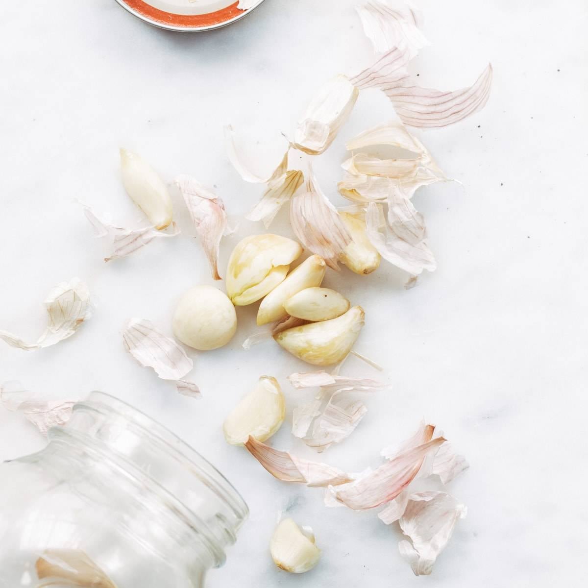 Cut garlic on a white surface.